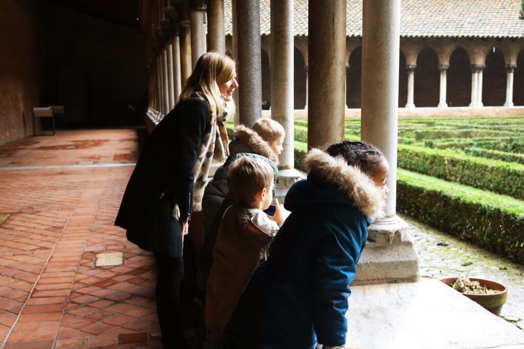 Groupe d'enfants qui regarde par dessus le muret du cloître du couvent des jacobins